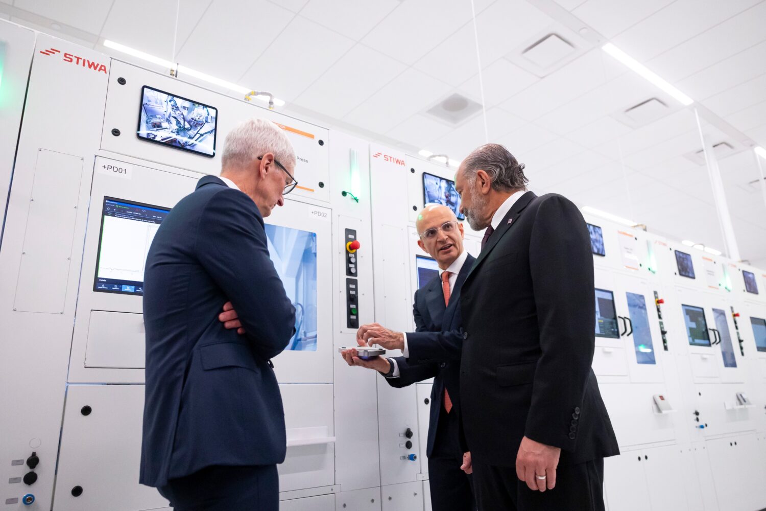 Apple COO Sabih Khan, center, and CEO Tim Cook, left, give U.S. Secretary of Commerce Howard Lutnic...