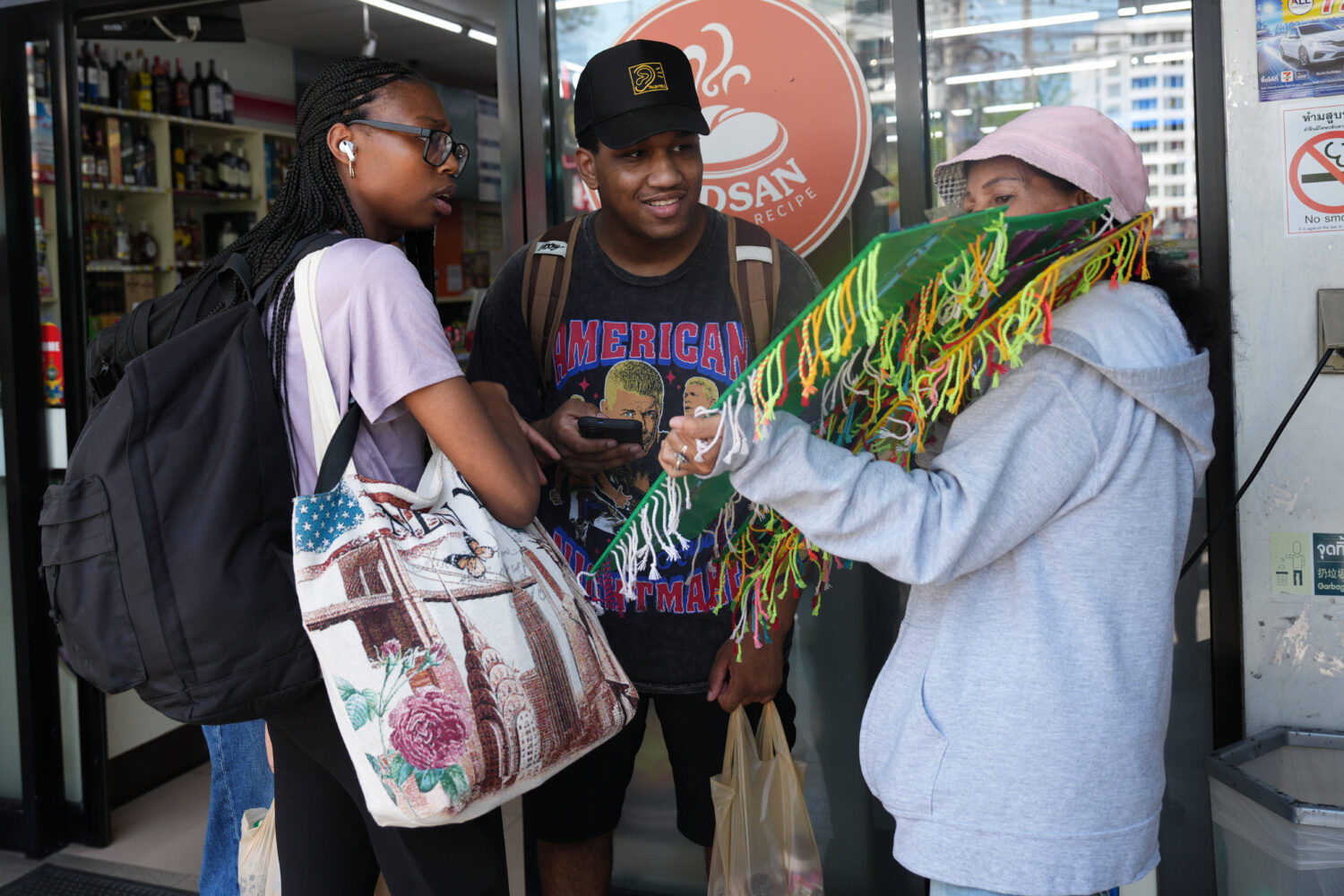 Crew members of the USS Abraham Lincoln talk to a souvenir vendor in Pattaya, Thailand, Thursday, S...