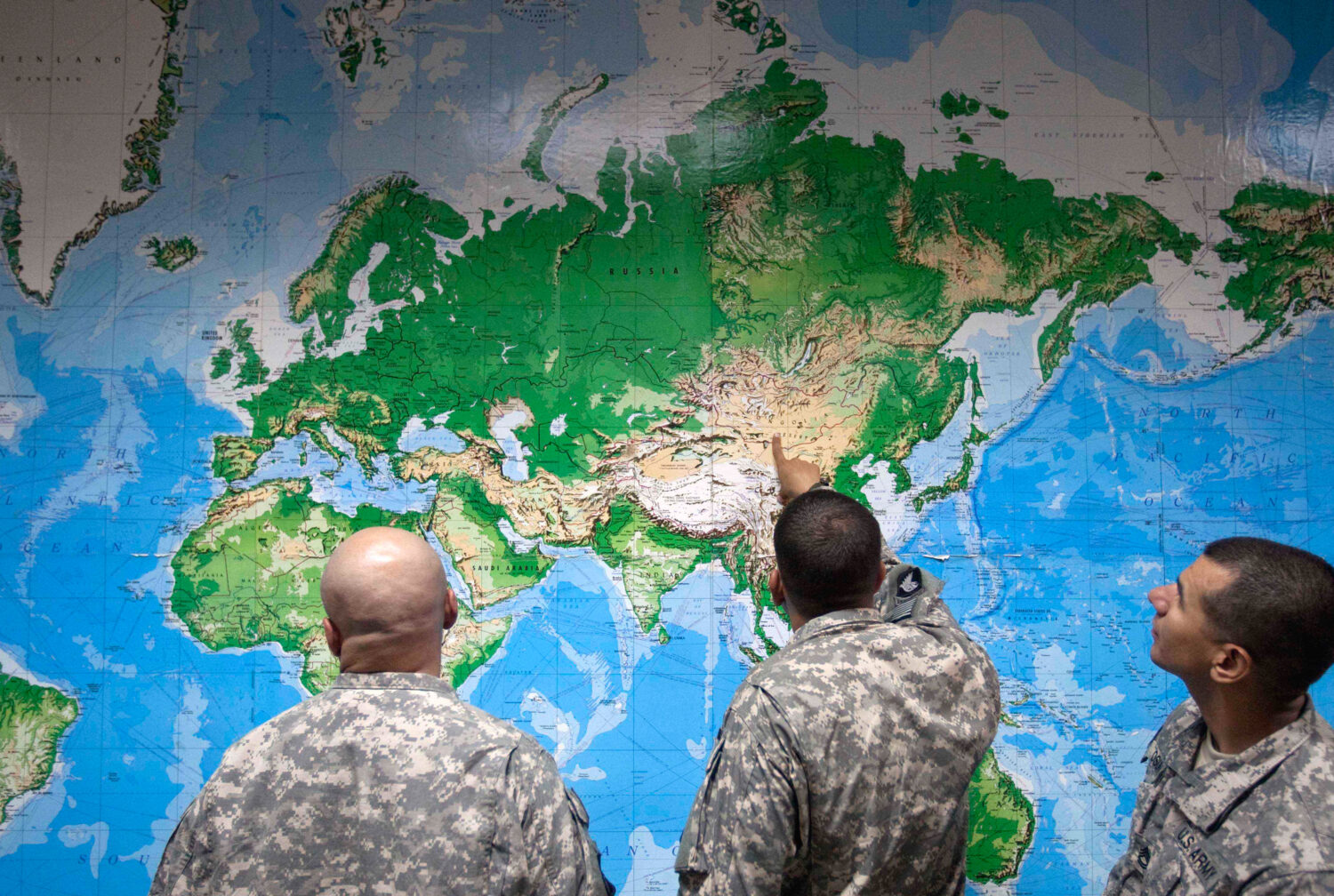 FILE - Soldiers look at a world map as they wait to board a flight in Manas, Kyrgyzstan, on the way...