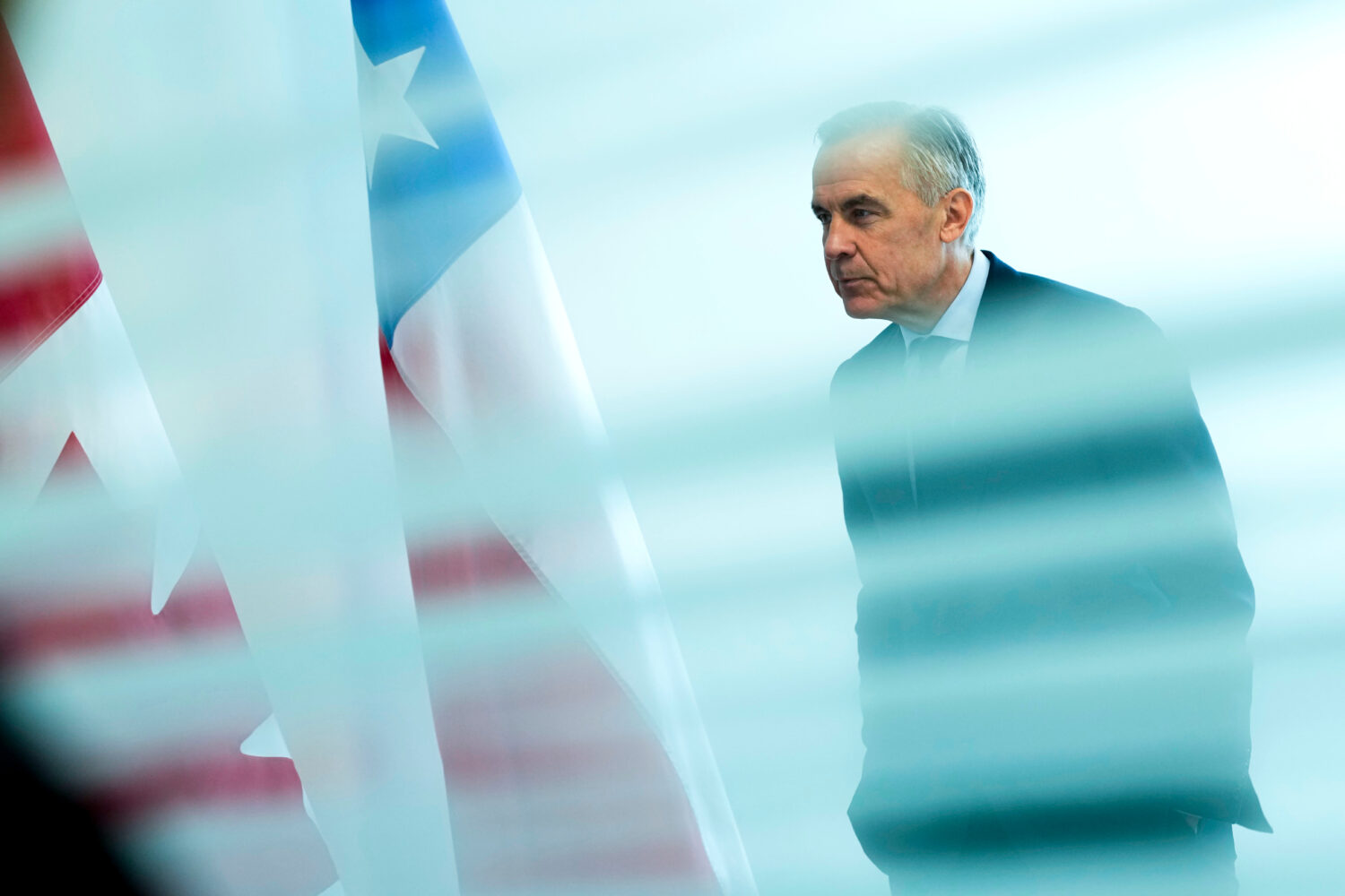 Canada Prime Minister Mark Carney is seen from behind a glass pane as he waits to meet with Preside...