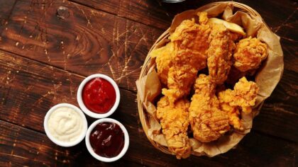 A basket of fried chicken, accompanied by small bowls of sauces. (Photo: Daniel_Dash via Envato)...