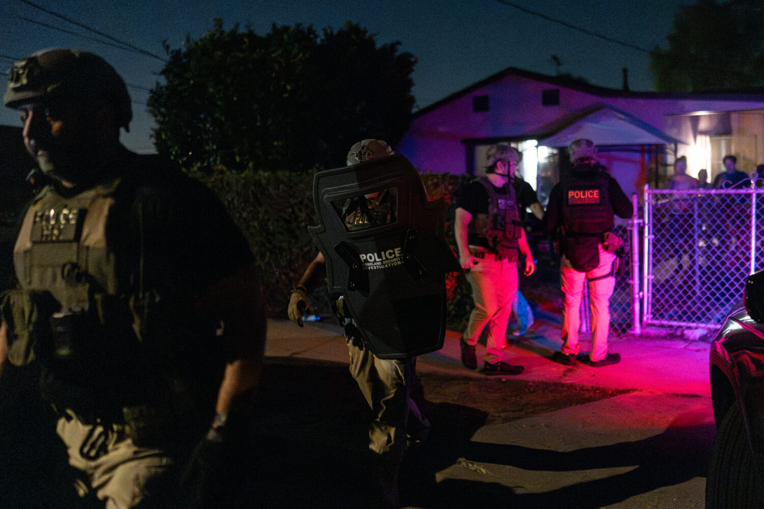 Homeland Security Investigations officers leave a home after arresting a suspect accused of illegal...