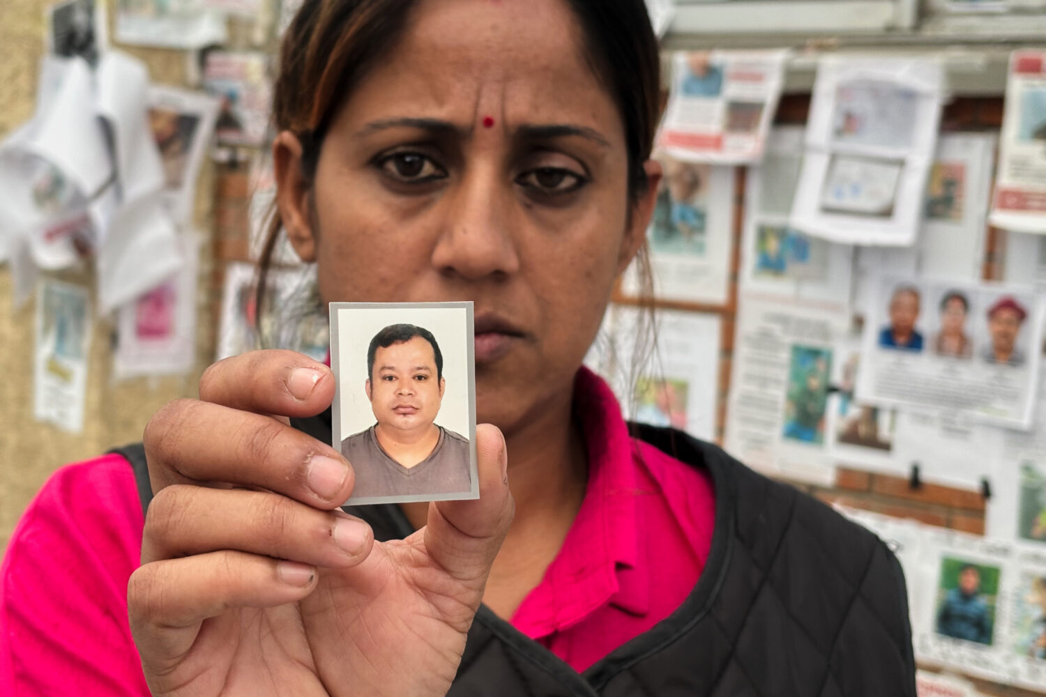 In this photo taken with a smartphone, Usha Khatri shows a photo of her husband Indra Bahadur who h...