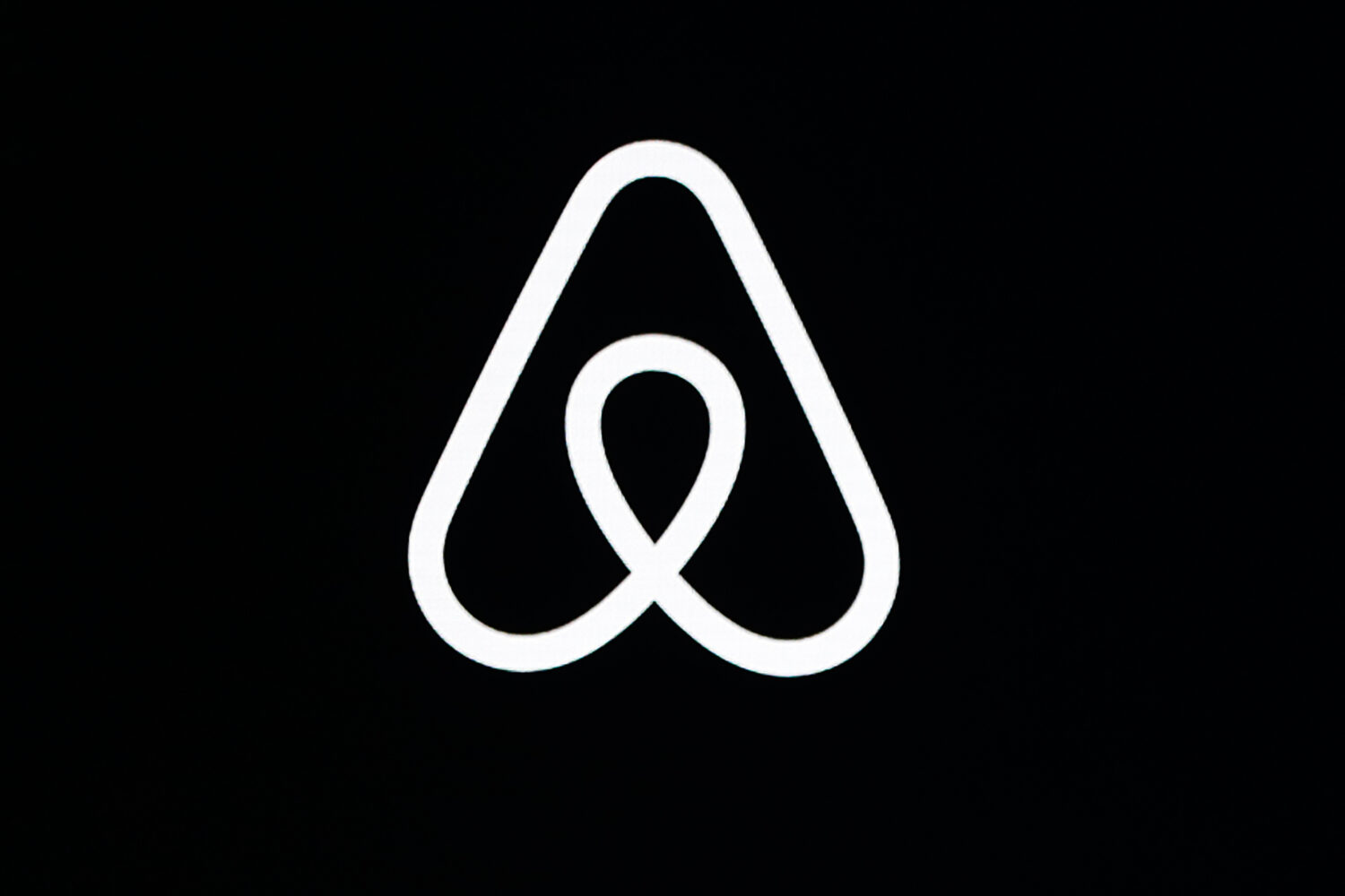 FILE - An Airbnb logo is displayed at an event in San Francisco on Feb. 22, 2018. (AP Photo/Eric Ri...