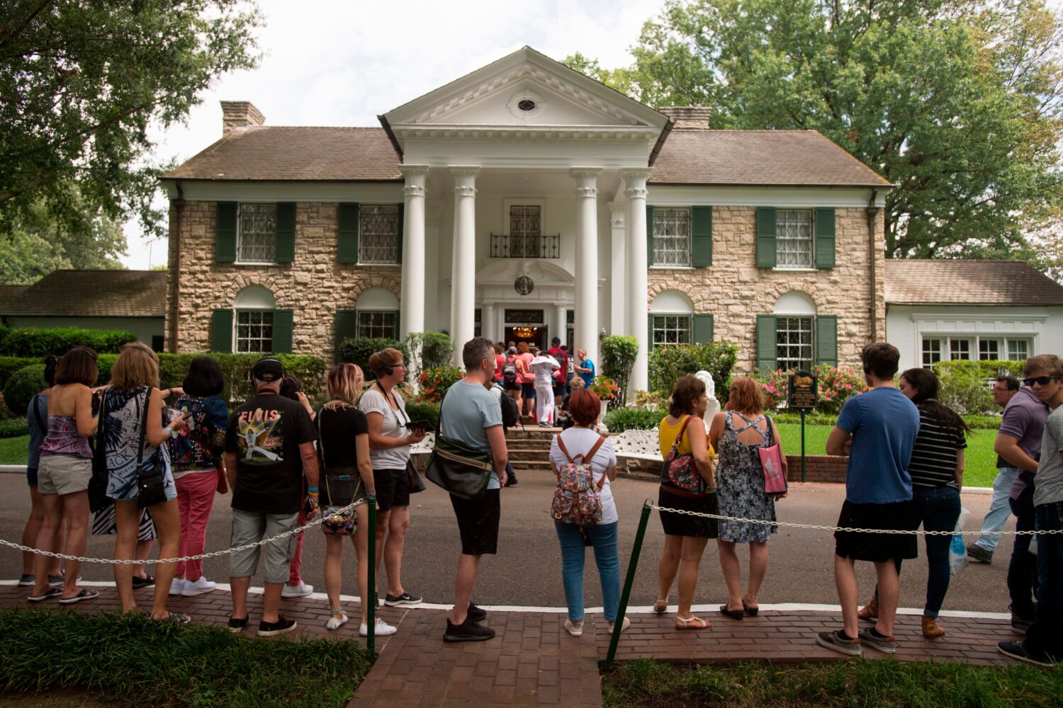 FILE - Fans wait in line outside Graceland, Elvis Presley's Memphis home, Aug. 15, 2017, in Memphis...