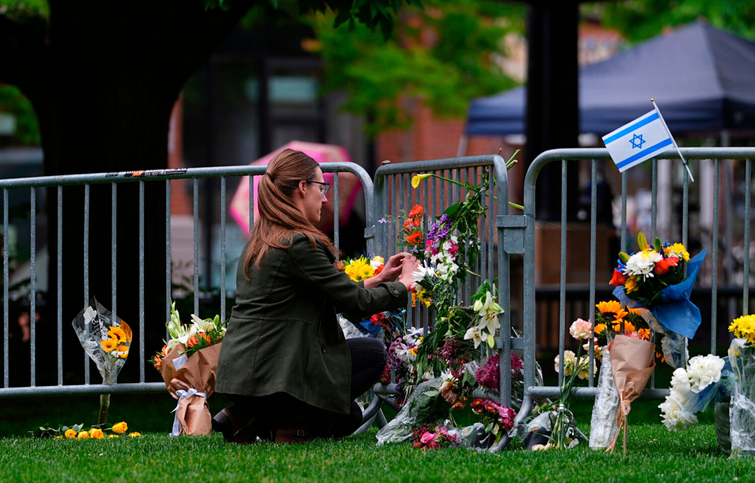 FILE - A woman places a bouquet of flowers at a makeshift memorial for victims of an attack outside...