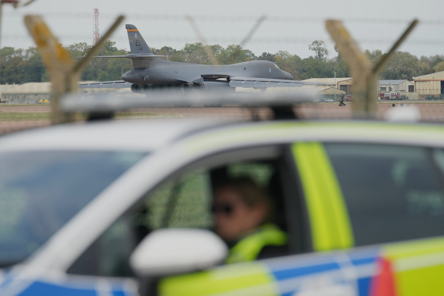 A B1 bomber prepares to take off as police officers man a checkpoint near RAF Fairford air base, in...