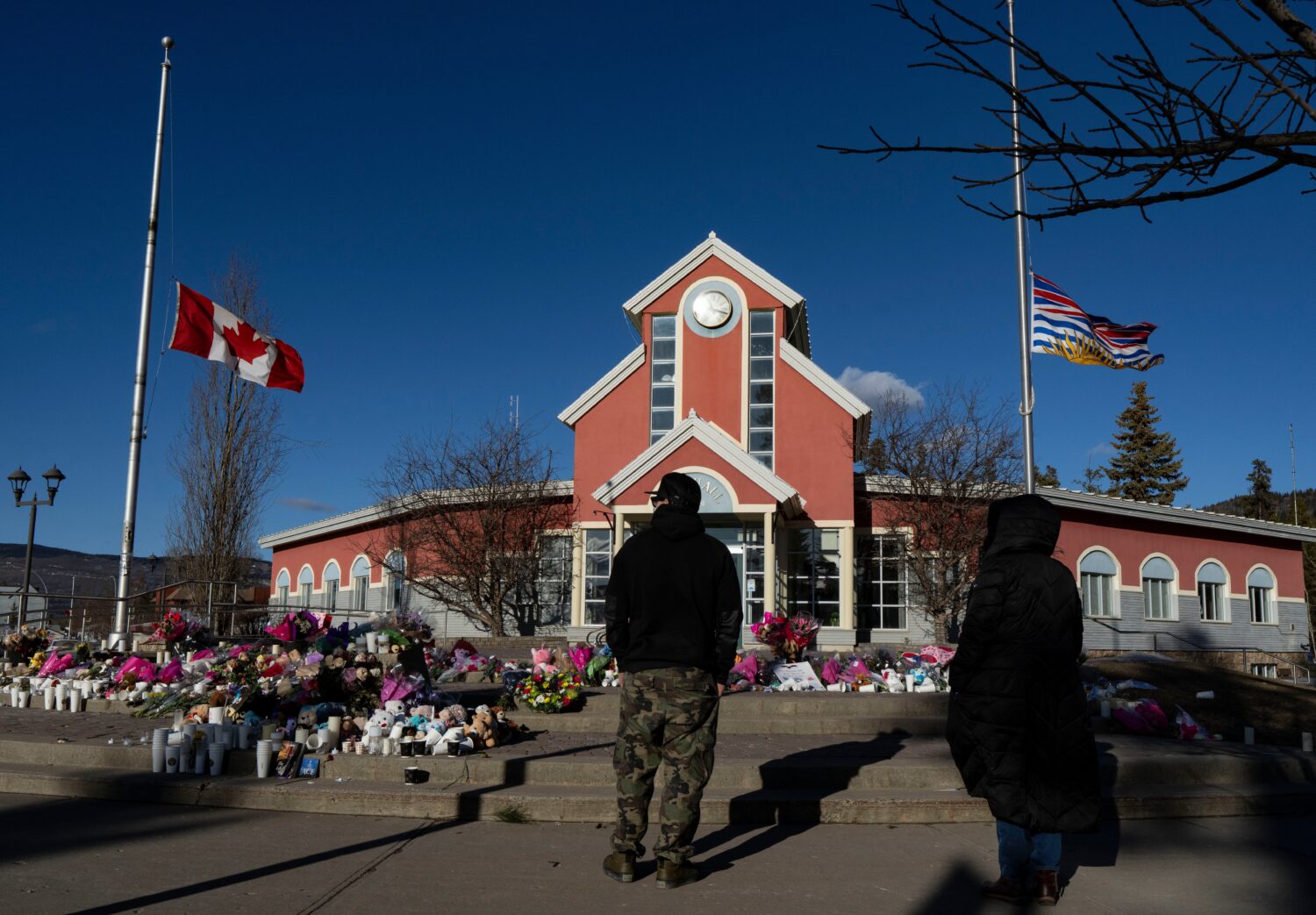 FILE - People pay their respects at a memorial on the steps of the Town Hall, following a vigil the...