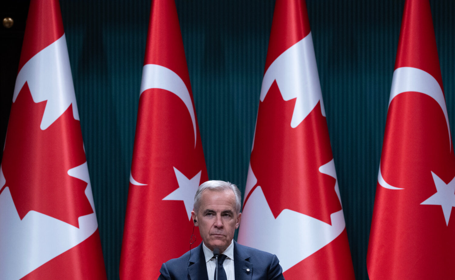 Prime Minister Mark Carney sits on stage and listens during a joint news conference with Turkish Pr...