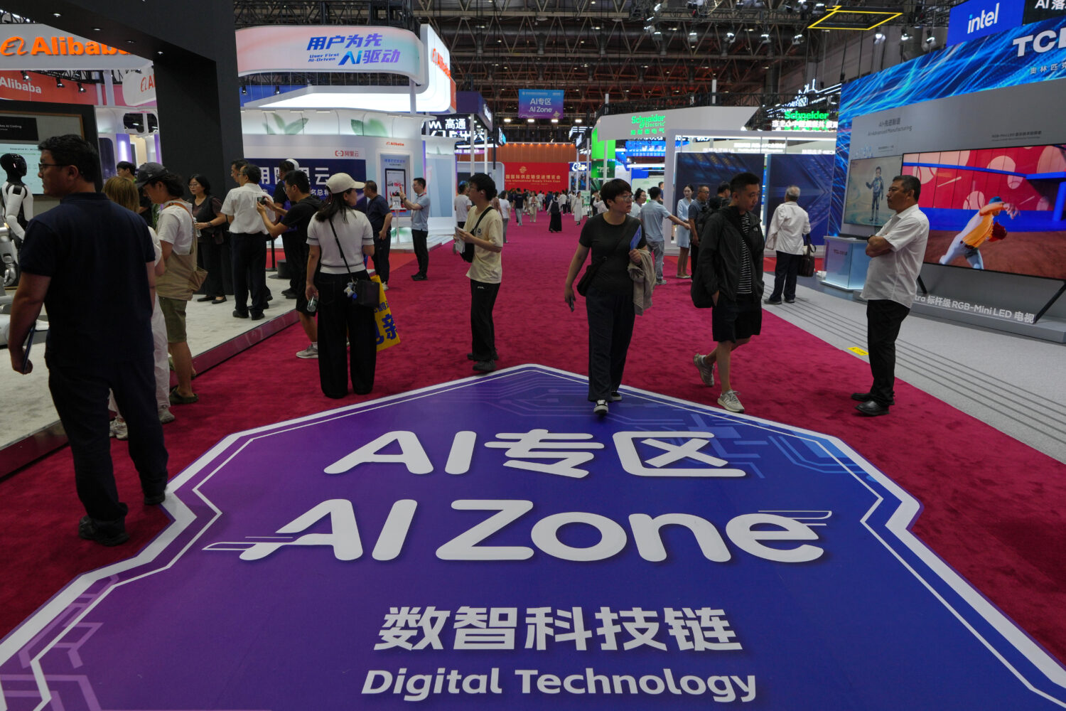 FILE - Visitors tour the exhibition booths operated with Artificial Intelligence (AI) at the China ...