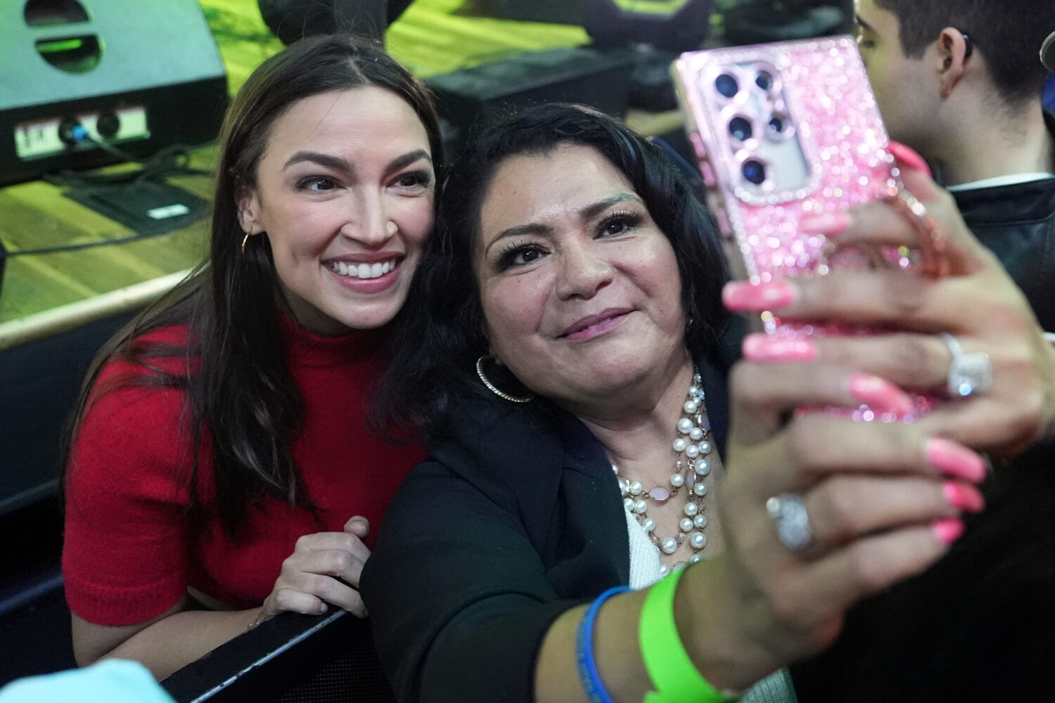 Rep. Alexandria Ocasio-Cortez, left, D-N.Y., poses for a photo with a supporter during a campaign r...