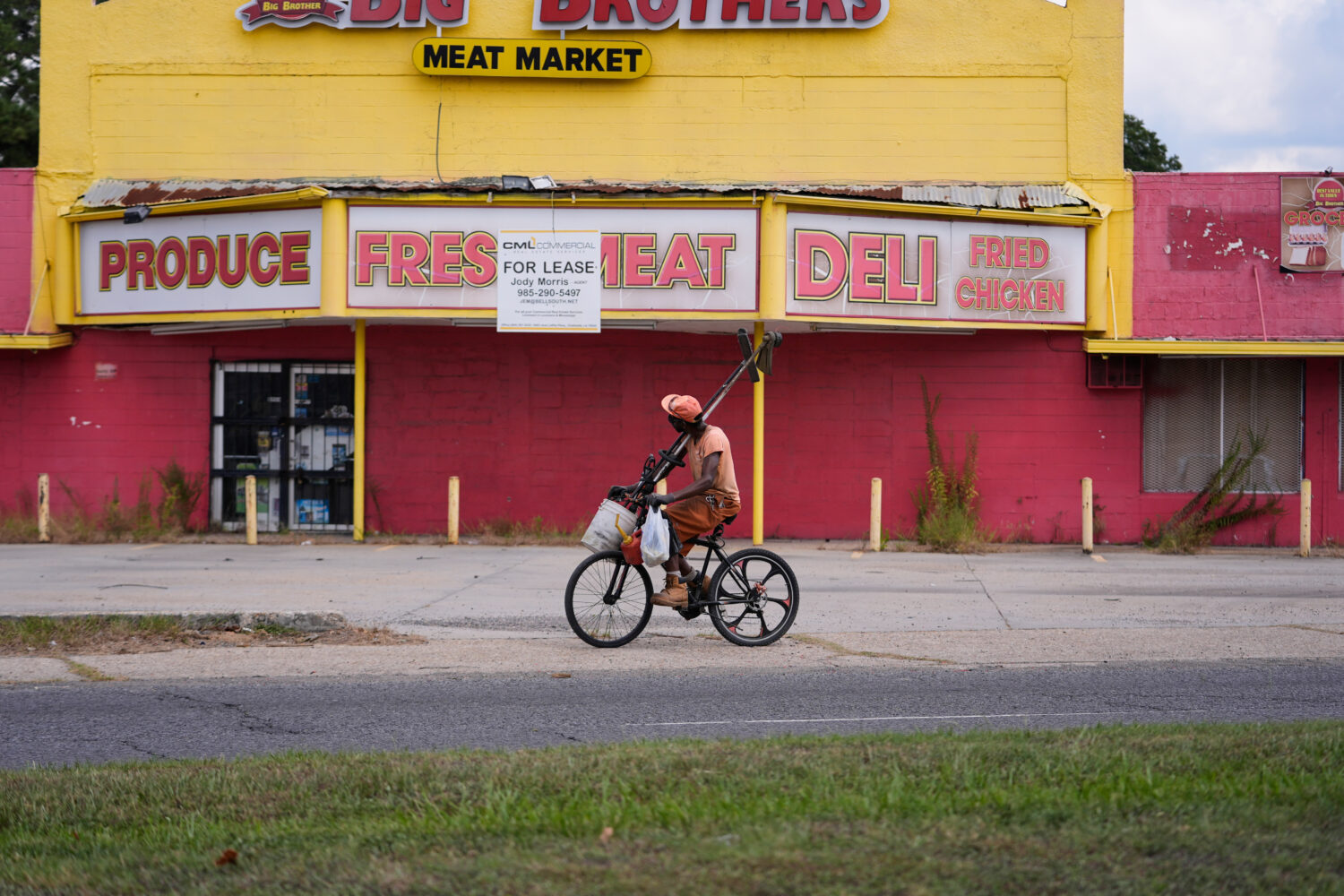 A man rides his bicycle past a closed meat market in the Scotlandville section of Baton Rouge, La.,...