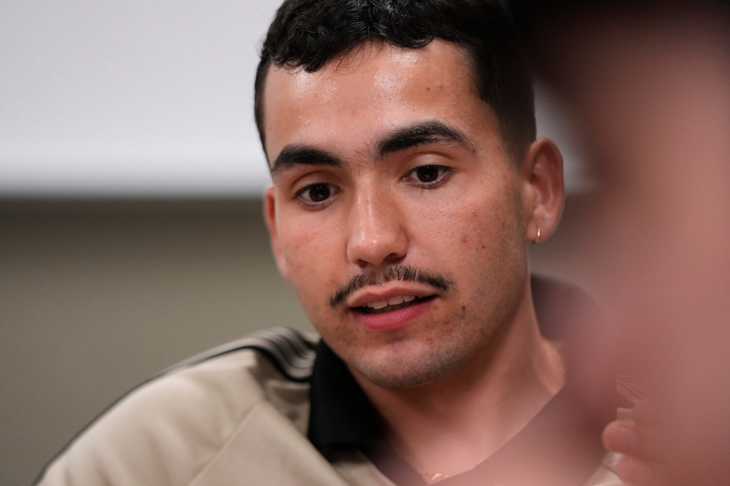Michigan State University senior Frankie Llerandi listens to a discussion at a campaign event for W...