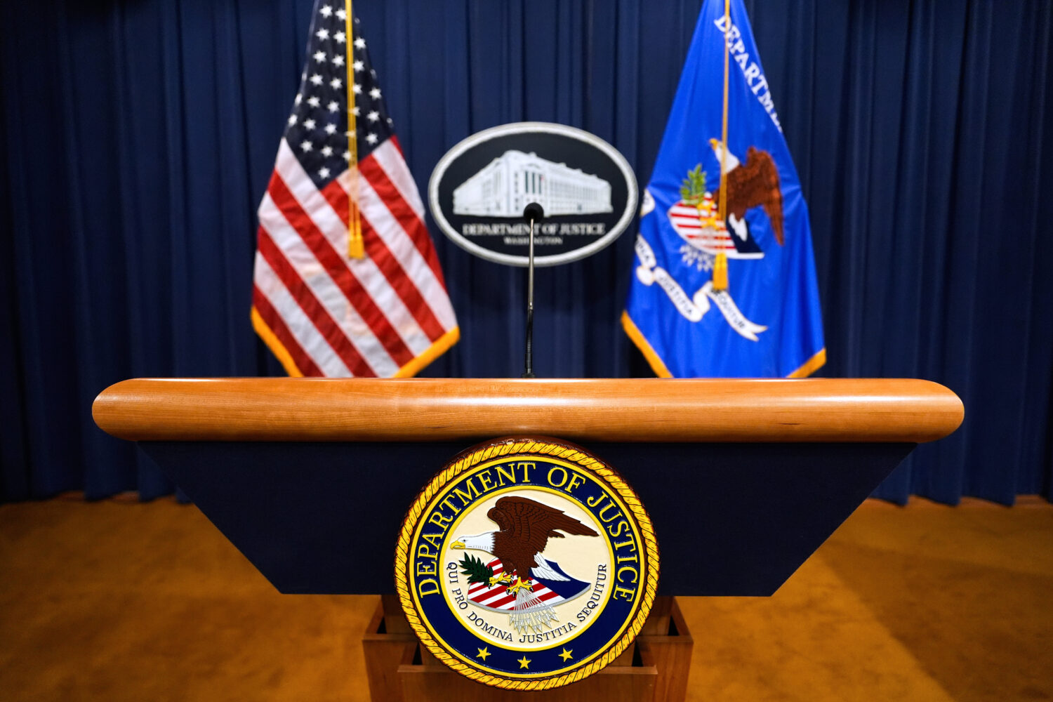 FILE - The U.S. Department of Justice logo is seen on a podium before a press conference, May 6, 20...