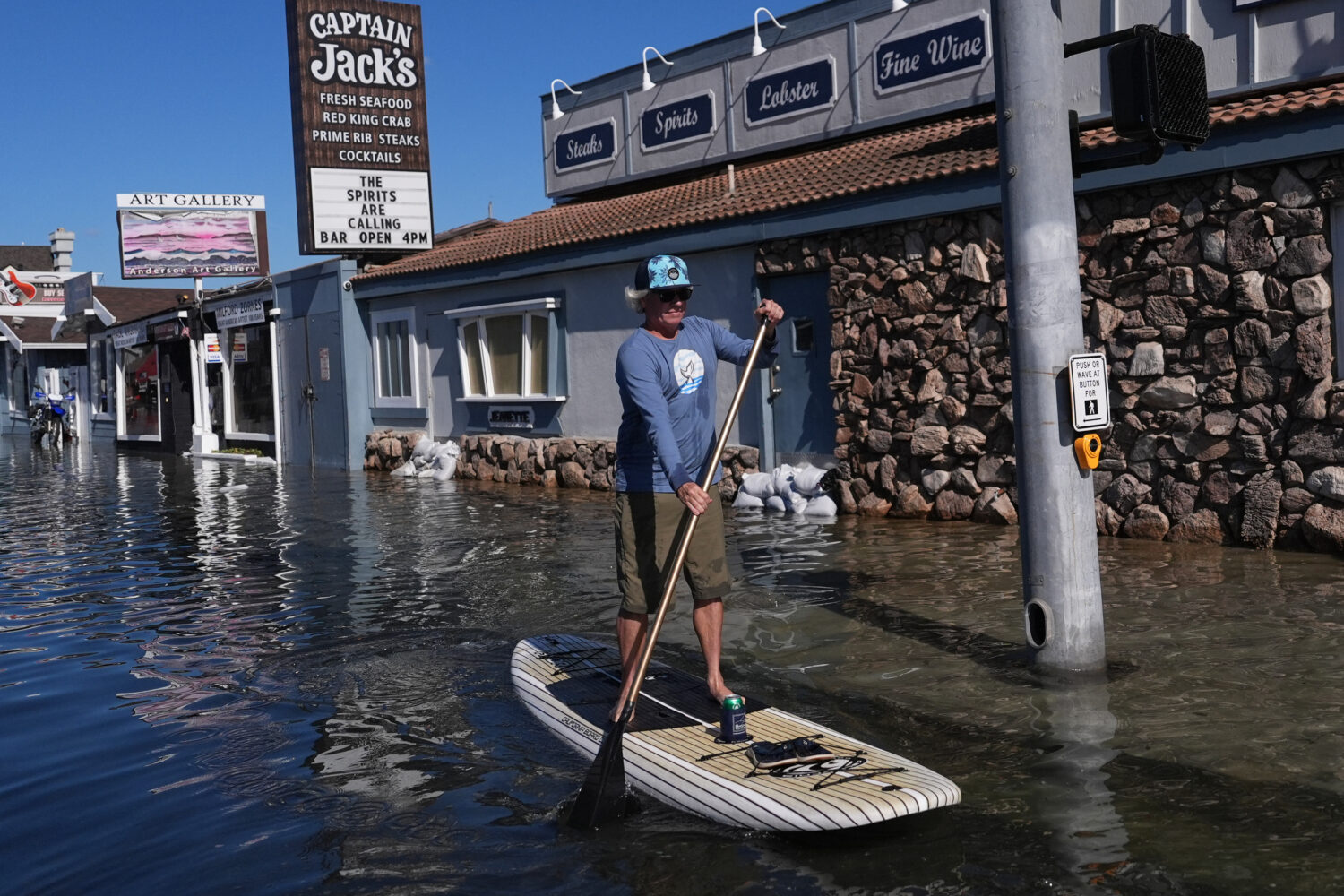 H.E. Durbin paddleboards in floodwaters in Huntington Beach, Calif., Wednesday, Oct. 28, 2026. (AP ...