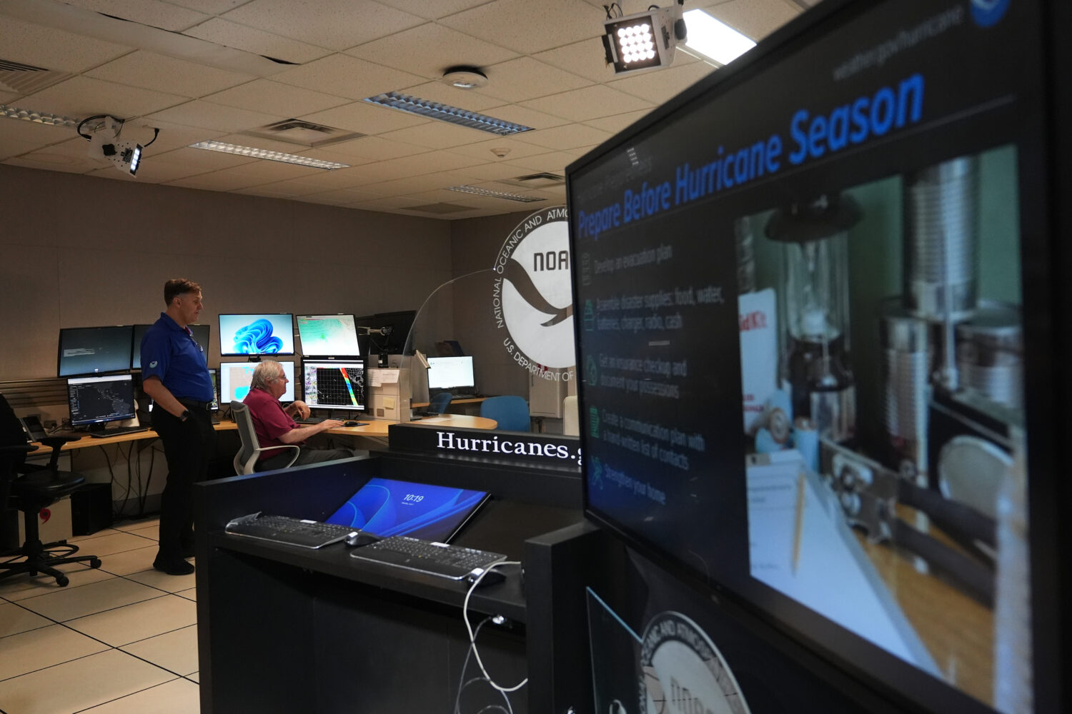 FILE - Senior hurricane specialists Eric Blake, left, and Richard Pasch, right, work at the Nationa...