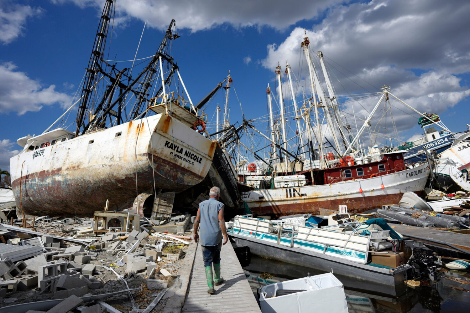 FILE - Bruce Hickey walks along the waterfront littered with debris and shrimp boats in the mobile ...
