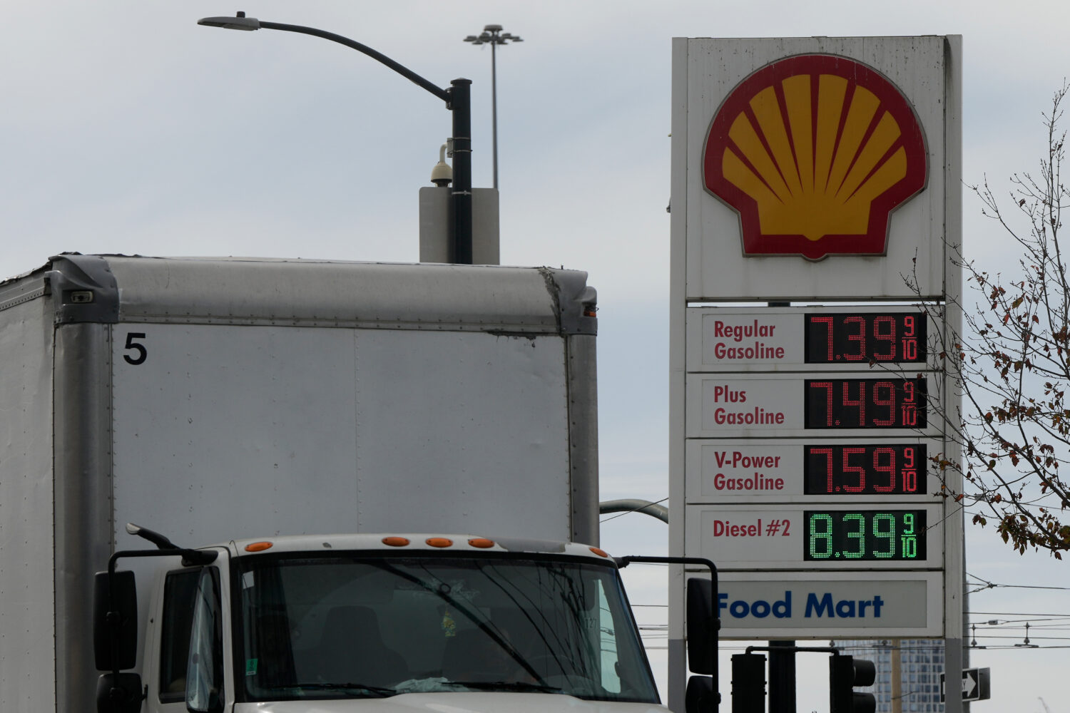 A truck drives past a fuel price board for gasoline and diesel at a gas station on Tuesday, Oct. 20...