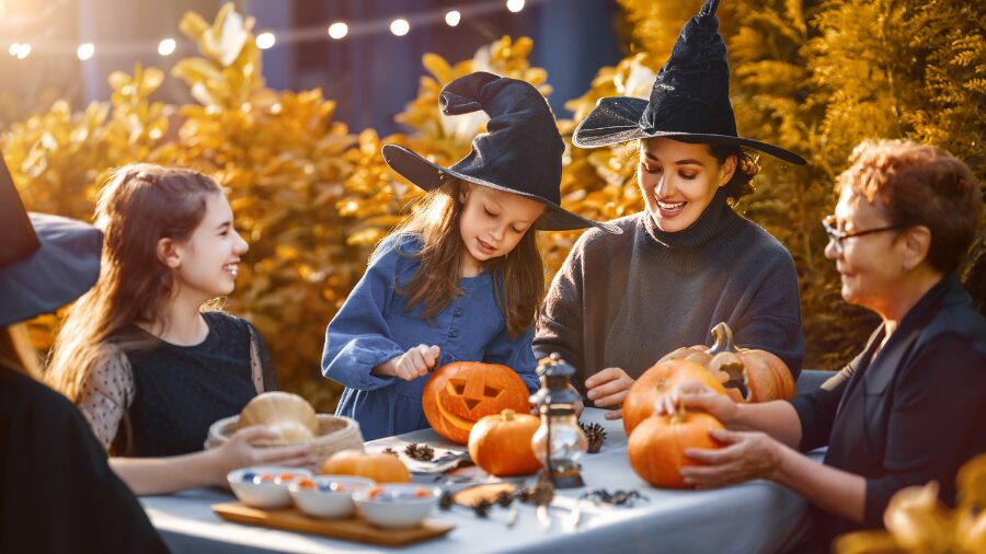 A family gathers at a table outdoors to celebrate Halloween. (Photo: choreograph via Envato)...