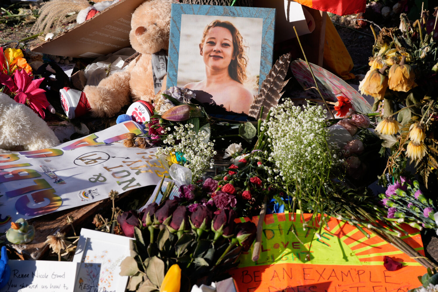 FILE - Flowers and photos are left at a memorial site for Renee Good on Saturday, Jan. 31, 2026, in...