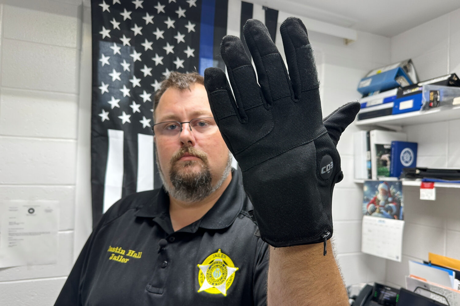 FILE - Nelson County, Ky., jailer Justin Hall shows an electric shock glove that is used at his fac...