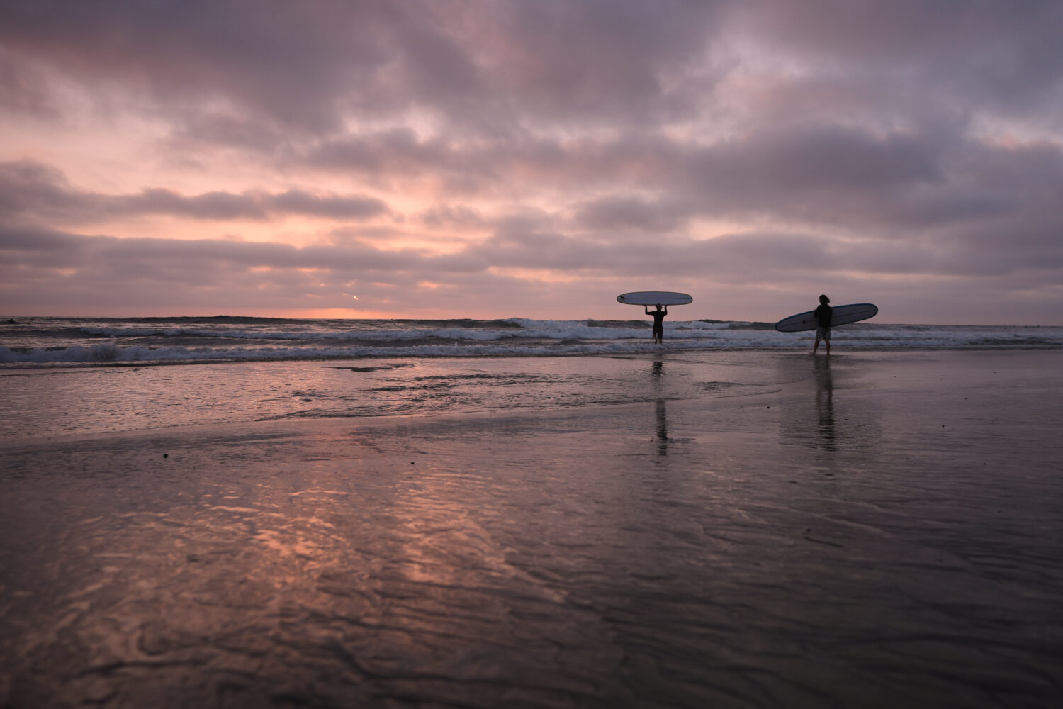 Surfers enter the Pacific Ocean as the sun sets Thursday, Oct. 1, 2026, in Encinitas, Calif. (AP Ph...