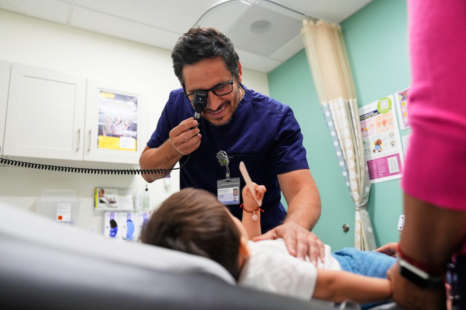 FILE - Pediatrician Irving Phillips examines a 16-month-old boy at a CommuniCARE+OLE clinic, June 2...