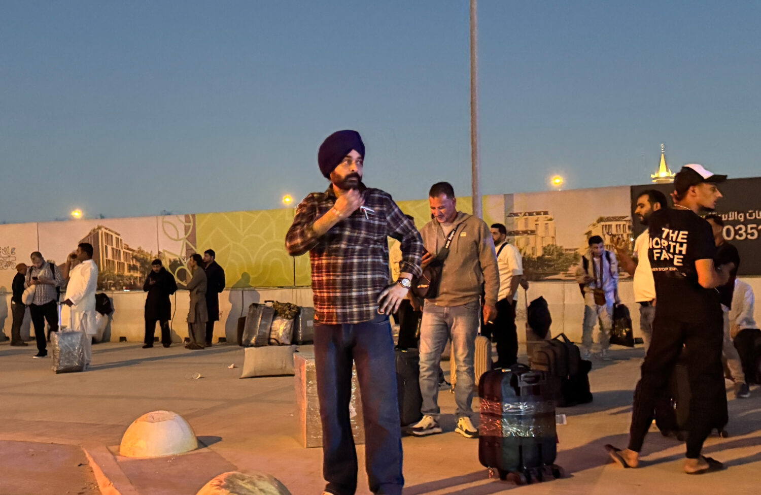 People gather outside a metro station on the road to King Khalid International Airport in Riyadh, S...