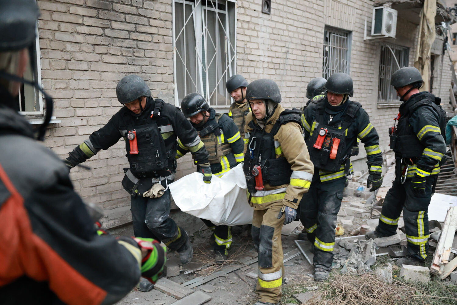 Rescue workers carry a body after pulling from the rubble of a residential building destroyed by a ...