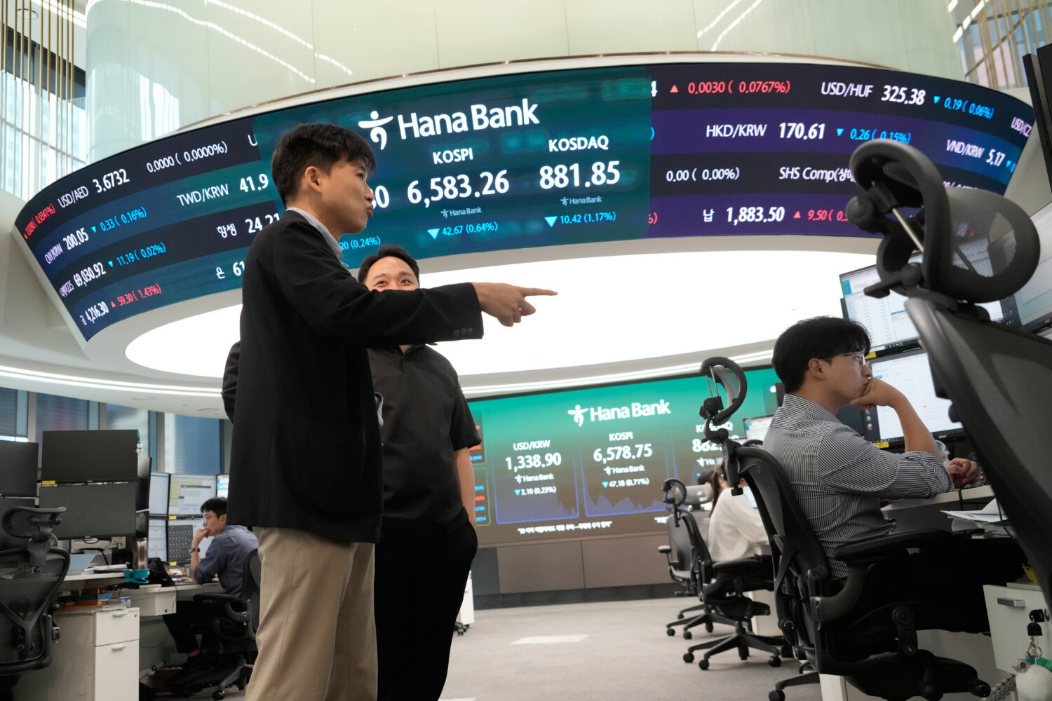 Currency traders work at the foreign exchange dealing room of the Hana Bank headquarters in Seoul, ...
