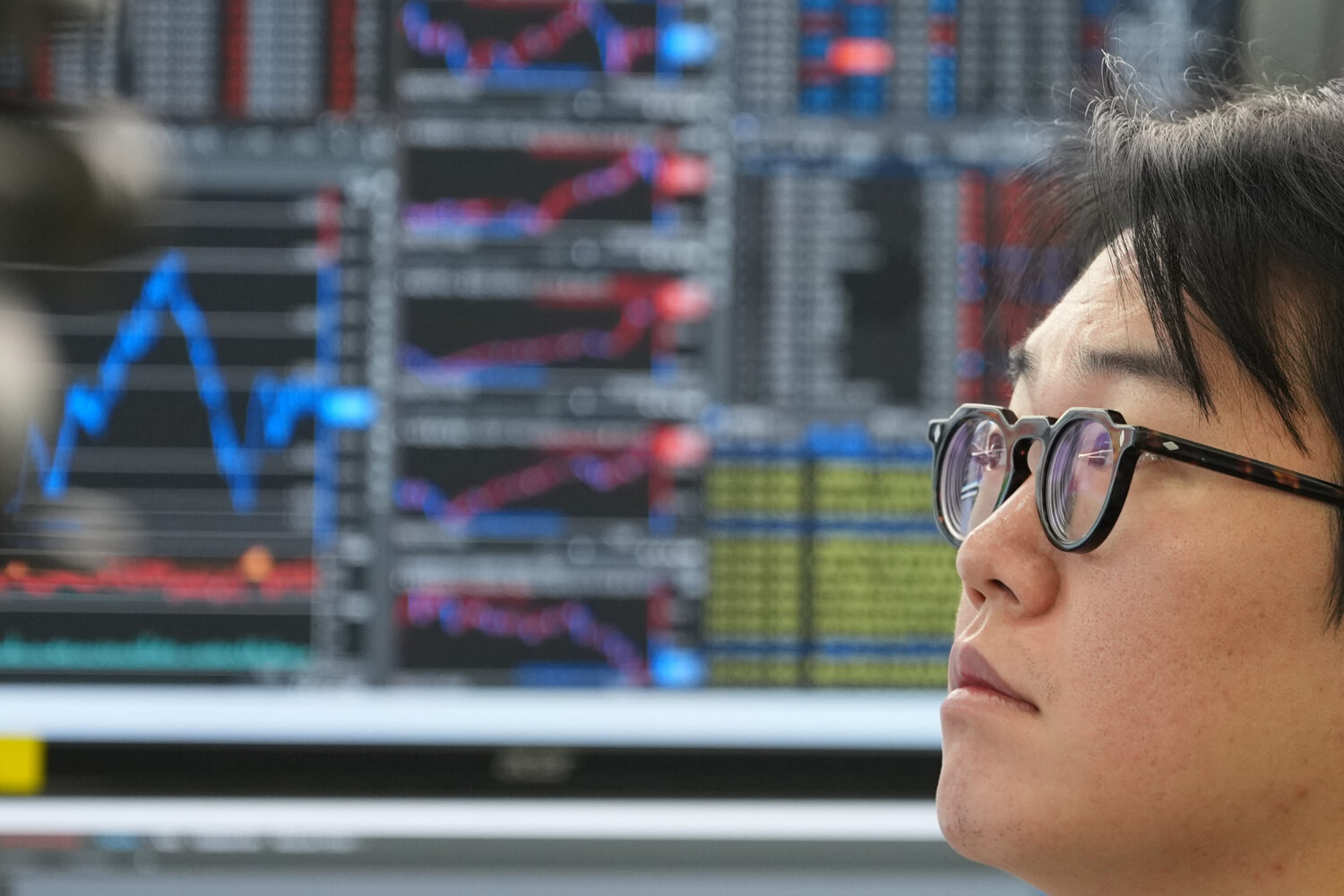 A dealer watches computer monitors at a dealing room of Hana Bank in Seoul, South Korea, Tuesday, O...