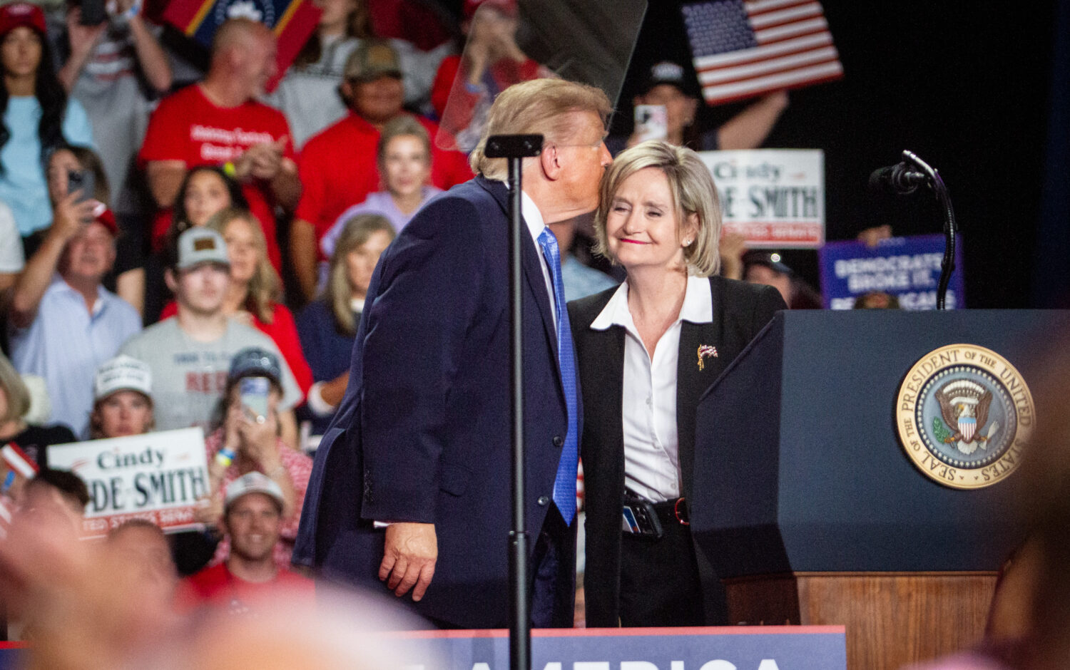 President Donald Trump shares a moment with U.S. Sen. Cindy Hyde-Smith on stage during a campaign r...