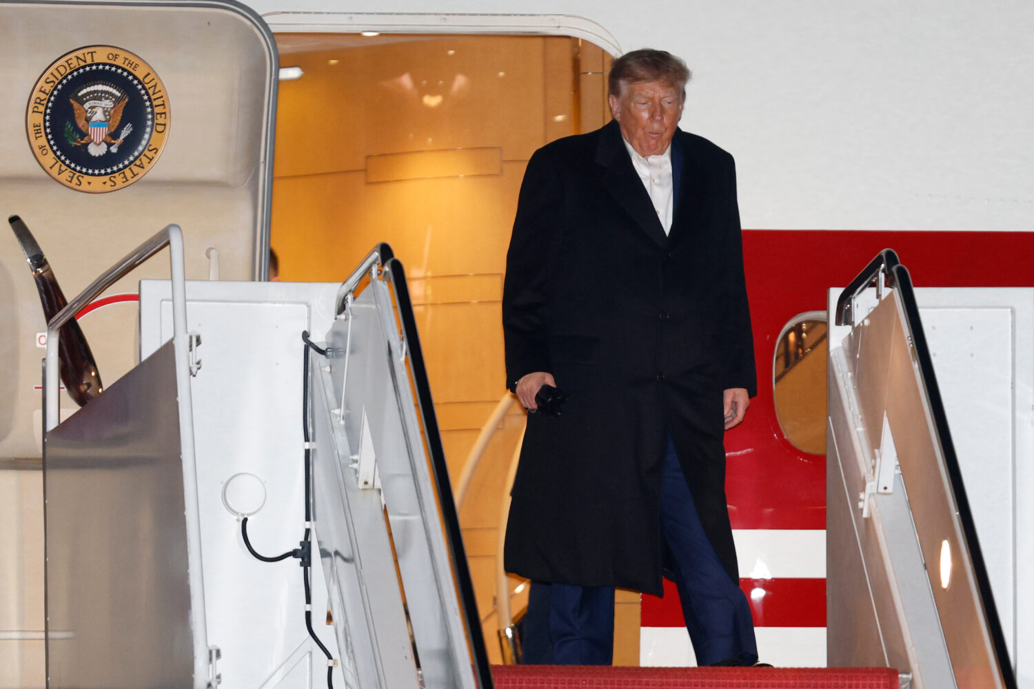 President Donald Trump walks down the stairs of Air Force One upon arriving at Joint Base Andrews, ...
