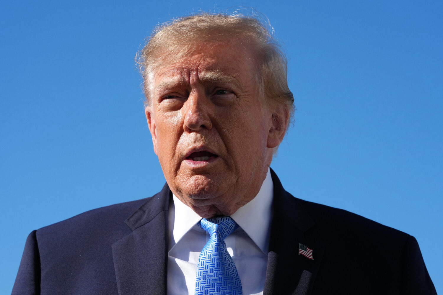 President Donald Trump talks to reporters before boarding Air Force One, at Joint Base Andrews, Md....