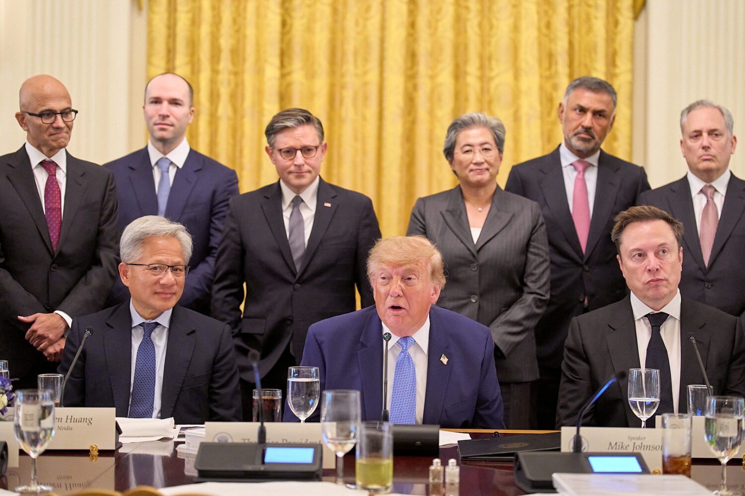 President Donald Trump, center, next to Nvidia CEO Jensen Huang, left, and Elon Musk, right, speaks...