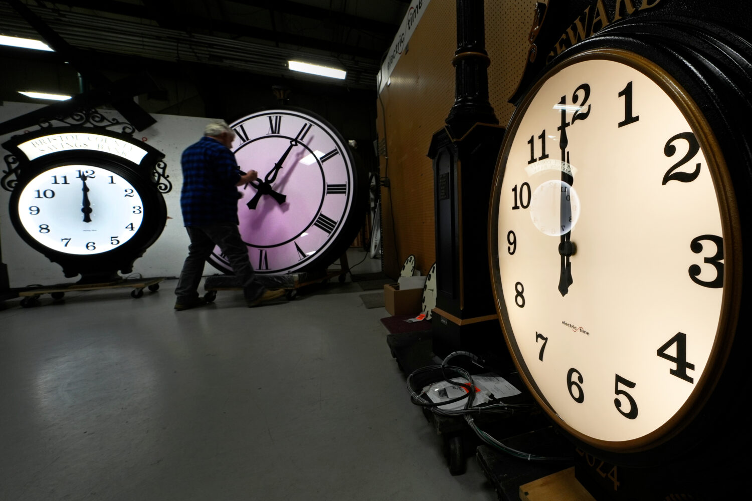 FILE - Clockmaker Scott Gow adjusts the hands of a clock at the Electric Time Company, Oct. 30, 202...
