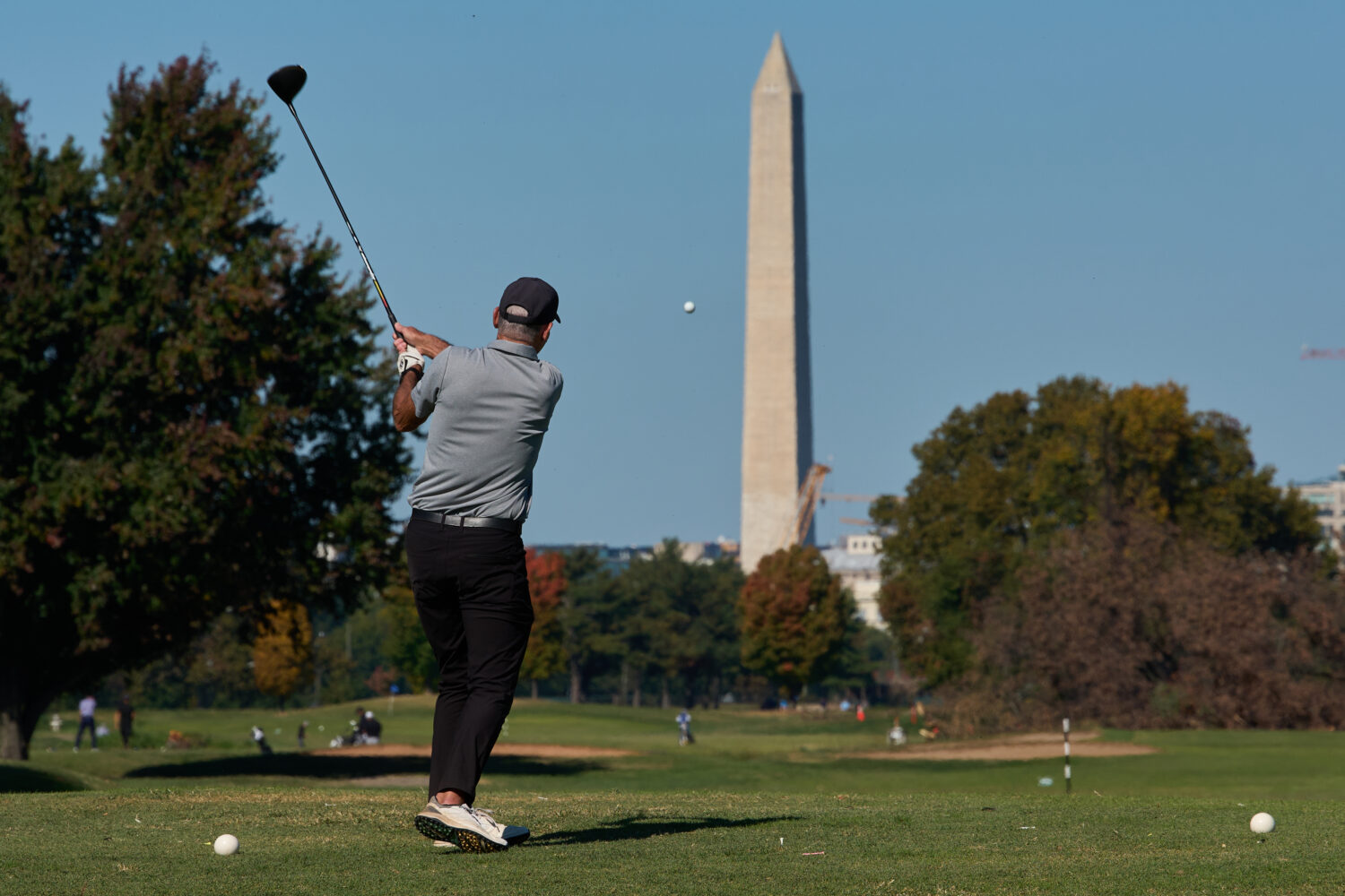 The Washington Monument is seen as a golfer takes a swing at East Potomac Park Golf Course, Monday,...
