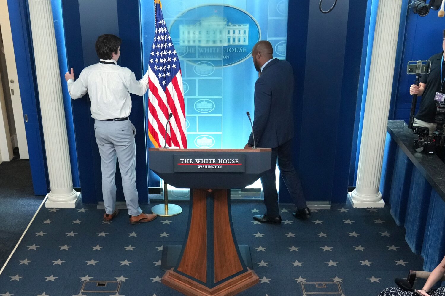 FILE - White House staff members remove monitors in the James Brady Press Briefing Room at the Whit...