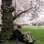 Master's student, Susan Mittge, enjoys the shade of a cherry tree while studying. 