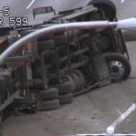 A firefighter surveys the damage of an overturned semi truck on southbound I-5 during the Thursday morning commute.