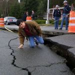 Then Washington Governor Gary Locke inspects a severe crack in Deschutes Parkway in Olympia after the magnitude 6.8 Nisqually quake in 2001. Worse damage is likely the next time the Cascadia fault ruptures off the Pacific coast. (AP archive photo by Lauren McFalls)