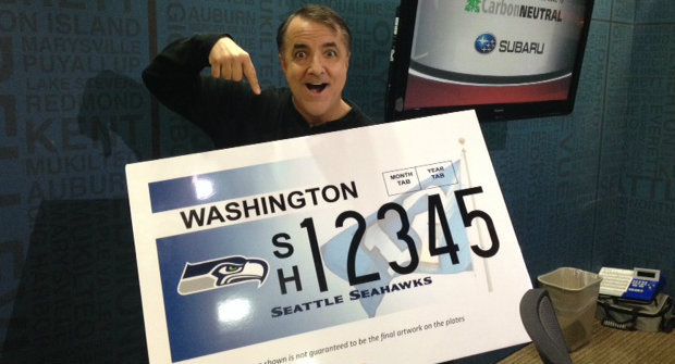 KIRO Radio’s Dori Monson models a mock up of the new Seahawks license plate now available in ...