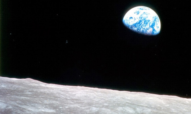 This photo released by NASA shows the Earth rising above the stark Moon, and was taken by Apollo 8 ...