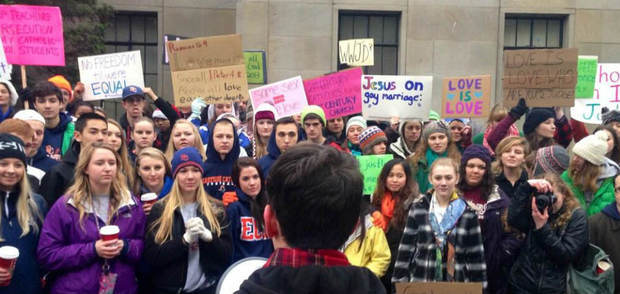 A student addresses others at a rally Friday in front of the Archdiocese of Seattle protesting the ...