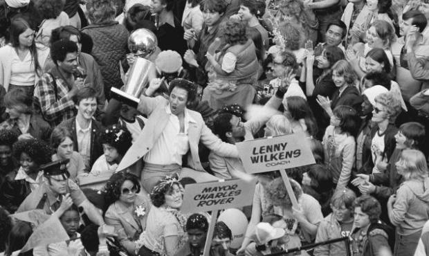 Lenny Wilkens holds up the NBA title trophy during the parade celebrating the SuperSonics 1979 worl...