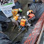 Crews work to remove a mammoth tusk found in Seattle's South Lake Union neighborhood.