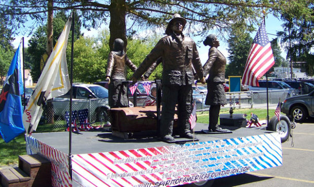 The sculpture features three figures, a firefighter, police officer and a flight attendant, holding...