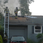 Seattle Fire crews work to put out the flames at a house fire they say was started when a man used a makeshift blowtorch to kill a spider. 