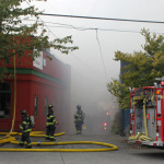 Firefighters battle smoke and flames as they work to put out a 2-alarm fire in Seattle's Fremont neighborhood, Tuesday, September 30, 2014.
