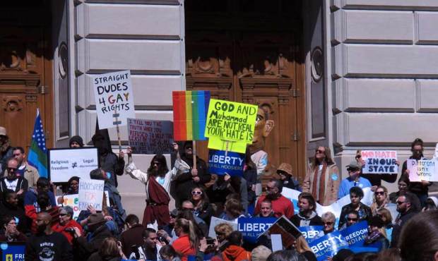 Some of the hundreds of people who gathered outside the Indiana Statehouse on Saturday, March 28, 2...